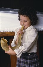 ENGLAND, Religion, Jewish, Young Jewish girl blowing the Shofar.