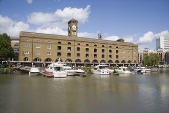 ENGLAND, London, St Catherine’s Dock with yachts moored next to the former warehouses which are now