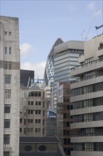 ENGLAND, London, "The Gherkin Swiss Re building seen, through tightly huddled buildings in the