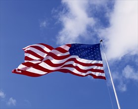 USA, Flags, American Stars and Stripes National Flag blowing in the wind against a blue sky with
