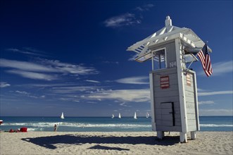 USA, Florida, Fort Lauderdale Beach, Lifeguard Tower displaying American flag with sailboats seen