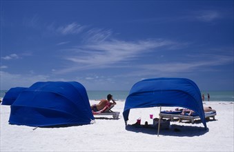USA, Florida, St Petersburg Beach, Blue wind breaks and sunbathers on sandy beach