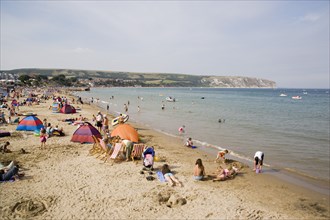 ENGLAND, Dorset, Swanage Bay, Sunbathers on sandy beach with colourful beach tents