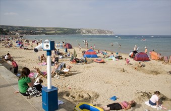 ENGLAND, Dorset, Swanage Bay, View across busy sandy beach with sunbathers on the sand towards the