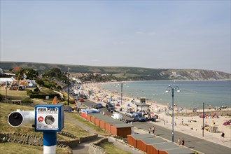 ENGLAND, Dorset, Swanage Bay, Elevated view across beach huts towards busy sandy bay with
