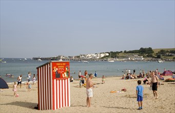 ENGLAND, Dorset, Swanage Bay, Small red and white striped Punch and Judy theatre on sandy beach