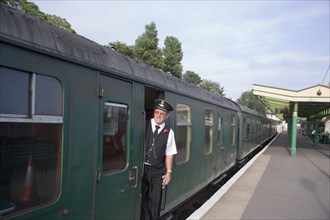 ENGLAND, Dorset, Swanage, Steam Railway Station. View along platform with train departing from