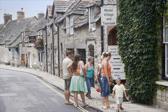ENGLAND, Dorset, Corfe, Visitors outside a Model Village and Tearoom shop in a row of traditional