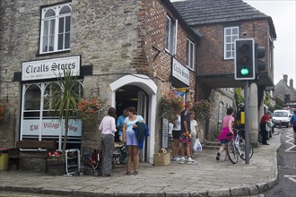 ENGLAND, Dorset, Corfe, People gathered outside a village shop