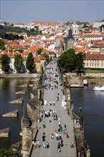 CZECH REPUBLIC, Bohemia, Prague, People walking across the Charles Bridge across the Vltava River