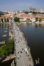 CZECH REPUBLIC, Bohemia, Prague, People walking across the Charles Bridge across the Vltava River