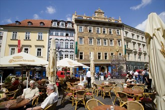 CZECH REPUBLIC, Bohemia, Prague, Old Town. People sitting at tables with umbrellas at street cafe