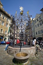 CZECH REPUBLIC, Bohemia, Prague, Old Town.Tourists around a water fountain with ornate metalwork in