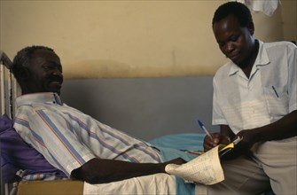TANZANIA, Shinyanga, Doctor taken patients notes in regional hospital.