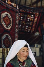 AFGHANISTAN, People, Kirghiz woman sat in yurt wearing traditional dress.