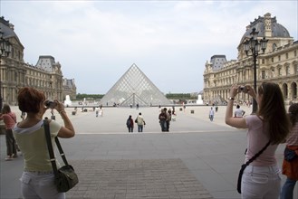 FRANCE, Ile de France, Paris, Tourists taking digital photographs of the pyramid entrance of the
