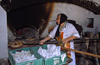BULGARIA, Etara, "Ethnographic Outdoor Village Museum, near Gabrovo. Old lady baking bread."