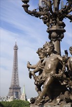 FRANCE, Ile de France, Paris, Ornate bronze lamp-post with cherubs on the Pont Alexandre III bridge