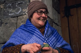 ARMENIA, People, "Portrait of smiling woman wearing blue shawl, hat and glasses and with several