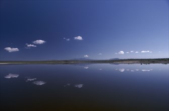 KENYA, Rift Valley, Lake Magadi, Still clouds reflected in Lake Magadi a placid soda lake