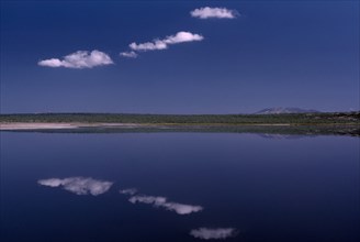 KENYA, Rift Valley, Lake Magadi, Still clouds reflected in Lake Magadi a placid soda lake