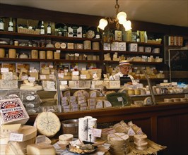 FOOD, Cheese, Man behind counter of specialist cheese delicatessen