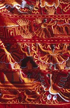 PERU, Near Cusco, Ollantaytambo, "Colourful patterned embroidered cloth in the market,