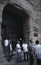 CHINA, Shanxi, Datong, Yungang Caves.  Chinese visitors at cave entrance in ancient Buddhist site
