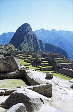 PERU, Cusco Department, Machu Picchu, "Inca ruins and Huayna Picchu, wall in foreground."