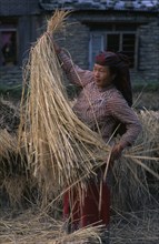 NEPAL, General, Woman in traditional dress with straw.