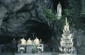 FRANCE, Midi-Pyrenees, Hautes-Pyrenees, Lourdes.  Priests conducting service at cave shrine in