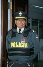 PERU, Cusco, Policeman in uniform wearing bullet proof clothing.