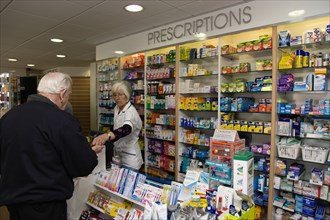 ENGLAND, East Sussex, Shoreham by sea, Interior of high street dispensing chemist  with male