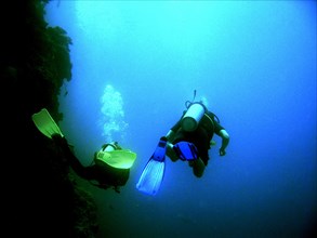 Australia, Queensland, Cairns, "Divers follow the outer edge of the reef, blackness below."