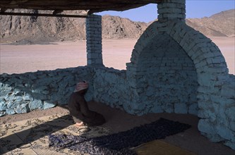 EGYPT, Religion, Islamic, Bedouin man worshipping in Eastern Desert Mosque made with brick and