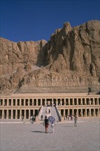 EGYPT, Nile Valley, Thebes, Deir el-Bahri. Hatshepsut Mortuary Temple. Visitors walking towards