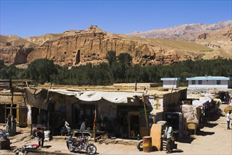 AFGHANISTAN, Bamiyan Province, Bamiyan , Main road in town infront of empty niche in cliffs where