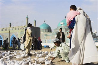 AFGHANISTAN, Mazar-I-Sharif, "Family feeding famous white pigeons at Shrine of Hazrat Ali (who was