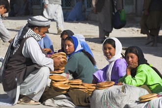 AFGHANISTAN, "Mazar-I-Sharif,", Man buying bread from girls