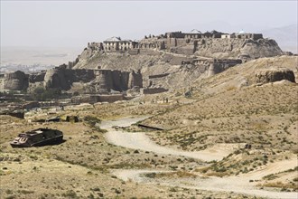 AFGHANISTAN, Ghazni, Military graveyard with ancient city walls and Citadel in background (the