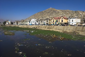 AFGHANISTAN, Kabul, Shah -do-Shamshira Mosque and shops line the banks of the polluted Kabul river