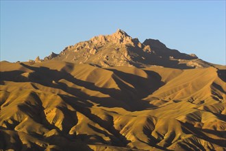 AFGHANISTAN, Bamiyan Province, Bamiyan, Late afternoon sun glows on mountains near the empty niche