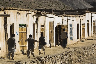 AFGHANISTAN, between Yakawlang and Daulitiar, Syadara, Boys running down street