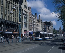 HOLLAND, Noord-Holland, Amsterdam, "Damrak.  Busy street scene, lined with shop, bar and hotel