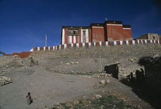 NEPAL, Mustang, Tsarang , "Red, grey and white exterior walls of Tsarang Monastery above flat roof
