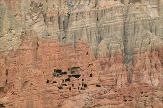 NEPAL, Mustang, Drakhmar, "Ancient cave dwellings in steep, eroded grey and orange coloured cliff