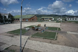 MONGOLIA, Gurwanbayan, Town centre with cattle grazing in public square and two people with