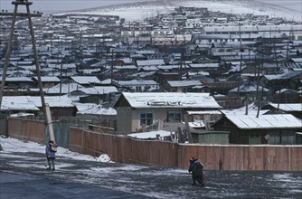 MONGOLIA, Ulan Bator, Snow covered rooftops of housing in city suburbs in winter with children