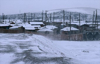 MONGOLIA, Ulan Bator, Traditional housing in city suburb in windblown winter snow.