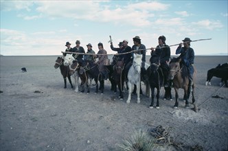 MONGOLIA, South Gobi, Festival, Young herdsmen circling camp abreast on horseback for ceremony of